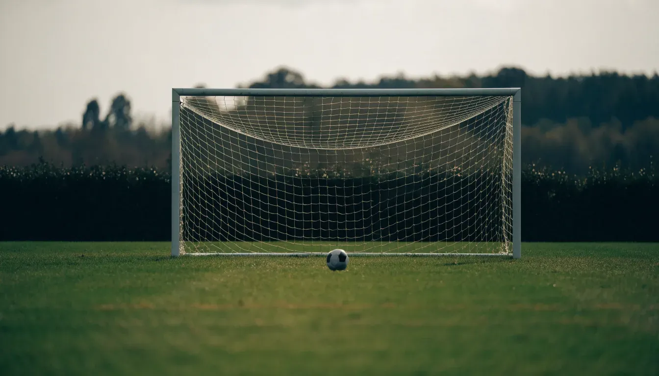 Ein Fussballtor mit locker hängendem Netz auf einem Trainingsplatz, das sich leicht im Wind bewegt.